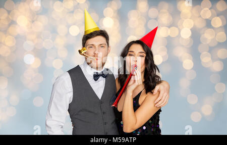 Coppia felice con party soffianti divertendosi Foto Stock