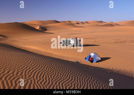 La Libia. Nei pressi di Ghat. VAN CASA mare di sabbia. Deserto del Sahara. Le dune di sabbia. I turisti in campeggio in dune di sabbia. 4x4 car. Tenda. Foto Stock