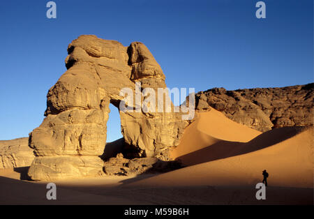 La Libia. Nei pressi di Ghat. Deserto del Sahara. Akakus (Acacus) Parco Nazionale. Arco Naturale chiamato Fezzenger. Tourist, donna. Foto Stock