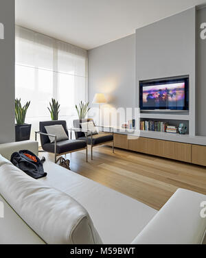 Scatti di interni di un moderno soggiorno in primo piano il cuoio beige divano sullo sfondo due in pelle e poltrone di ferro, il pavimento è realizzato o Foto Stock