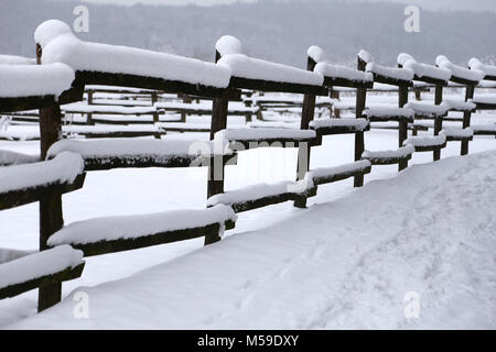 Favoloso paesaggio invernale con neve fresca su rurale staccionata in legno a fattoria degli animali Foto Stock