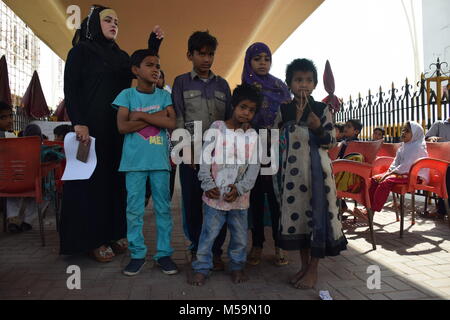 Karachi, Sindh, Pakistan. Xiv Feb, 2018. Syeda Anfas capo della Scuola di sentiero porta un paio di bambini di strada per la scuola che sono senza indumenti e senza scarpe per fornire loro istruzione gratuita.Il Pakistan è un paese con i più bassi di istruzione servizi per le famiglie povere in Asia. Residente locale Syeda Anfas istituito tre sentiero scuola nella città di Karachi per fornire servizi di formazione per oltre 5000 bambini di strada per libero. Una delle scuole è situato presso il sottopasso ponte di Karachi famoso vicino al Abdullah Shah Ghazi santuario. (Credito immagine: Foto Stock