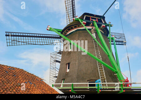 L uomo sulla scala di decorazione, il mulino a vento di Zaanse Schans un villaggio nei pressi di Zaandijk nel comune di Zaanstad, North Holland, Paesi Bassi. Foto Stock