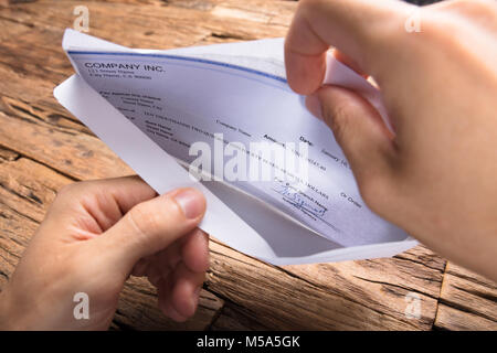 Mani tagliate di imprenditore apertura della busta con stipendio Foto Stock