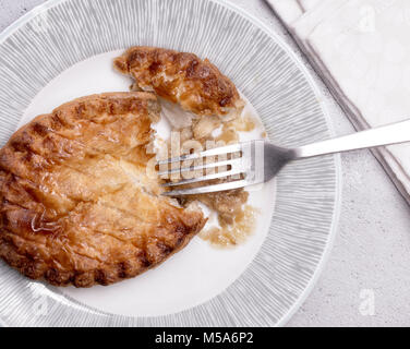 Vista aerea di un grafico a torta di pollo su una piastra con forcella e igienico. Foto Stock