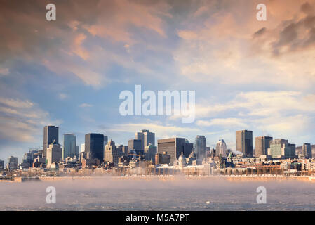 Il vapore ascendente dal congelati St Lawrence river a sunrise, con il quartiere centrale della Vecchia Montreal in background. Foto Stock