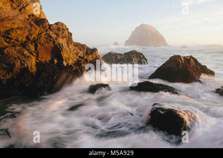 Seascape con le onde che si infrangono sulle rocce al tramonto. Foto Stock