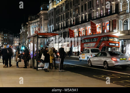 Traffico di persone e di veicoli su Regent Street, una delle principali strade dello shopping nel West End di Londra. Foto Stock