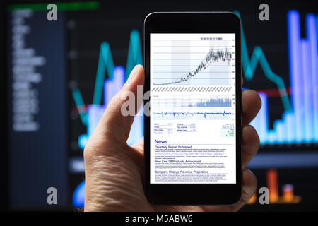 Appendere umano utilizzando il telefono cellulare con grafici azionari sullo schermo Foto Stock