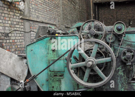 Vecchio vintage disfunzionali macchinari utilizzati per la produzione di tessuti con cinghie e grandi ruote Foto Stock