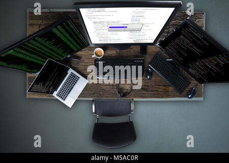 Angolo di Alta Vista di più sullo schermo del computer che mostra barra di avanzamento della copia del file sulla scrivania Foto Stock