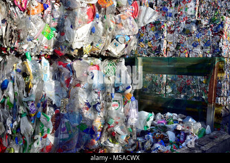 Rifiuti post-consumo di bottiglie in plastica e lattine compresso in bails e impilati in impianto di riciclaggio Foto Stock