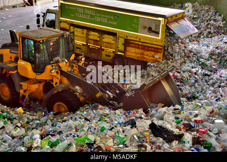 Rifiuti post-consumo, bottiglie di plastica e lattine, portato in impianto di riciclaggio dai camion di raccolta essendo spostata da un trattore per operazioni di ordinamento, REGNO UNITO Foto Stock