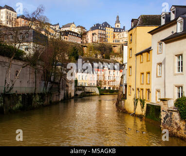 Una vista del fiume Alzette come esso passa attraverso il Grund trimestre nella città di Lussemburgo, Lussemburgo, e le Ville Haute trimestre sulla parte in alto a sinistra, highli Foto Stock