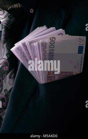 Negli uomini le tute di 500 euro. Tangenti e corruzione con banconote in euro. Foto Stock
