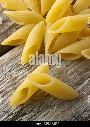 Secchi tradizionali bronzo Italaian Mezze Penne Rigate pasta chiudere in su in un ambiente rustico in legno Foto Stock