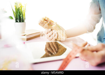 La donna e la dieta di frutta mentre si lavora sul computer in ufficio Foto Stock