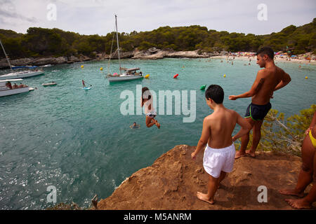 Ragazza diving dalle rocce in Cala en Turqueta, Menorca,Isole Baleari, Spagna Foto Stock