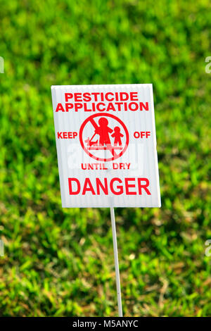 L'applicazione di pesticidi cartello di avviso su un bastone in un prato in Florida USA Foto Stock