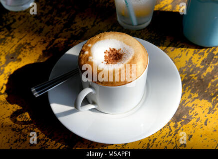 Cappuccino caldo il caffè la mattina foto in tempo reale in sunrise mattina calda illuminazione e bassa luce e ombra scura. Foto Stock