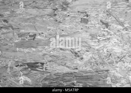 Irregolari sullo sfondo di legno di flakeboard. Miscela approssimativa delle forme di legno Legname in foglio di materiale - elaborazione monocromatica Foto Stock