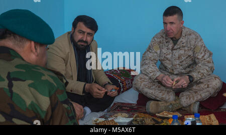 Il sig. Hayatullah Hayat, governatore della provincia di Helmand, e Briga. Gen. Benjamin T. Watson, comandante generale della Task Force a sud-ovest di conversare e condividere un pasto dopo la NASRAT Shura a Camp Shorabak, Afghanistan, il 10 febbraio, 2018. Il funzionamento è NASRAT afghana per la difesa nazionale e le forze di sicurezza' 1397 Programma annuale per ottenere e mantenere l'iniziativa attraverso l'azione offensiva ed espandere il controllo demografico. (U.S. Marine Corps Foto Stock