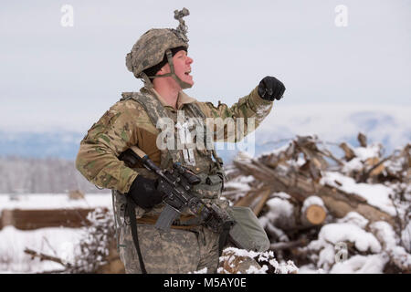 Spc. Zackery Williams, assegnato alla società di caricabatterie, 1° Battaglione, quinto reggimento di fanteria, 1° Stryker Brigade Combat Team, XXV divisione di fanteria, U.S. Esercito di Alaska, grida le direzioni di compagni soldati durante il funzionamento conca a base comune Elmendorf-Richardson, Alaska, il 10 febbraio, 2018. Funzionamento Conca è stato un battaglione-livello, bracci combinato, live-esercizio di incendio che si è concentrato sulla letalità artico. Durante il funzionamento di tre 150-soldato aziende manovrato attraverso vari terreni; attaccando e cogliendo le posizioni nemiche nonché eliminando le principali armi e veicoli essendo utilizzati dal nemico. (U Foto Stock