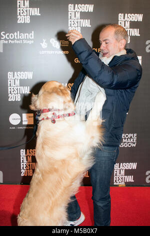 Glasgow, Scotland, Regno Unito. Il 21 febbraio, 2018. Jeremy Dawson (produttore) e VisitScotland 'Ambassadog,' George, sul tappeto rosso a una foto chiamata per la UK film premiere di Isle of Dogs, presso la Glasgow Film Theatre (GFT), in Scozia. Questo screening è parte del filamento di Gala presso la Glasgow Film Festival 2018 (GFF), che corre tra il 21 febbraio e il 4 marzo, 2018. Iain McGuinness / Alamy Live News Foto Stock