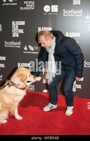 Glasgow, Scotland, Regno Unito. Il 21 febbraio, 2018. Jeremy Dawson (produttore) e VisitScotland 'Ambassadog,' George, sul tappeto rosso a una foto chiamata per la UK film premiere di Isle of Dogs, presso la Glasgow Film Theatre (GFT), in Scozia. Questo screening è parte del filamento di Gala presso la Glasgow Film Festival 2018 (GFF), che corre tra il 21 febbraio e il 4 marzo, 2018. Iain McGuinness / Alamy Live News Foto Stock