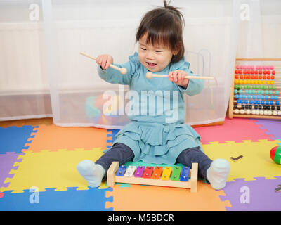 Baby girl xilofono giocare a casa Foto Stock