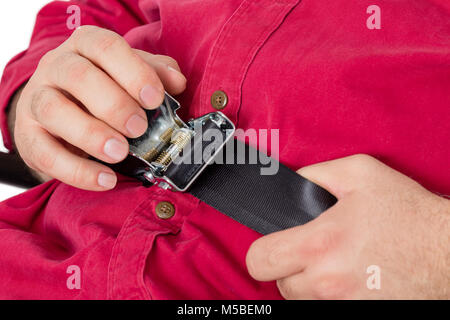 Regolazione passeggero e serraggio di una cintura di sicurezza su un velivolo come egli tira sulla cinghia con le mani in una vista ravvicinata Foto Stock