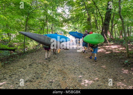 Un gruppo di kayakers che trasportano i loro kayak lungo il fiume Potomac a Great Falls Foto Stock