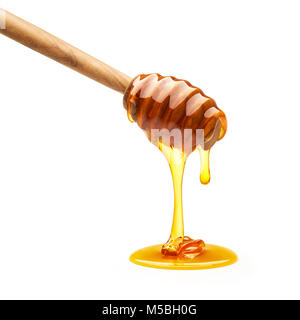 Il miele sgocciola dal bilanciere isolati su sfondo bianco Foto Stock