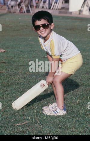 Ragazzo allegramente a giocare a cricket al Parco Shivaji, Dadar, Bombay, India Foto Stock