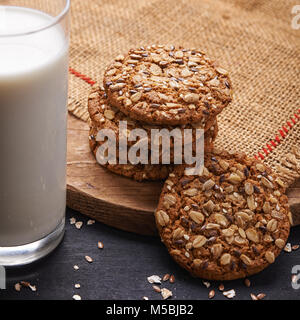 Avena e semi di cookie e bicchiere di latte su sfondo di legno. vista superiore Foto Stock