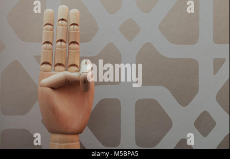 Articolato a mano in legno con tre dita sollevate in allusione al numero tre, su uno sfondo di stile vintage wallpaper Foto Stock