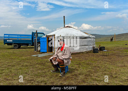 Anziani, maschi nomade in abito tradizionale udienza davanti al suo yurt, Mongolia Foto Stock