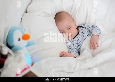 Chidl malati, bab boy giacente a letto con la febbre, in appoggio a casa Foto Stock