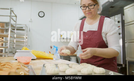 Materie torta da mani - femmina baker Foto Stock