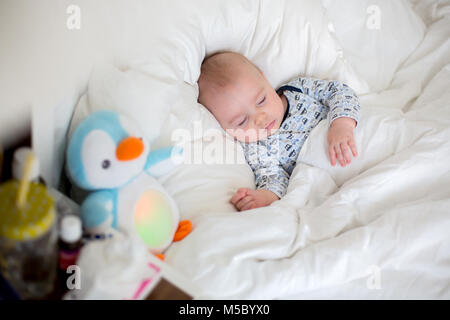 Chidl malati, bab boy giacente a letto con la febbre, in appoggio a casa Foto Stock