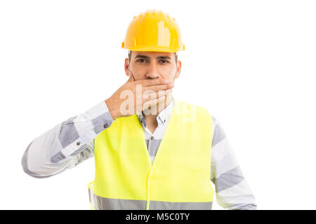 Costruttore o builder che copre la sua bocca giallo da indossare casco e giubbotto isolati su sfondo bianco come silenzio muto concetto segreta Foto Stock