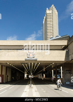 London, England, Regno Unito - 3 Luglio 2014: Un ciclista fuoriesce dal tunnel sotto la brutalist alloggiamento Barbican station wagon sulla B100 Beech Street nel Ci Foto Stock