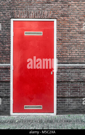 Red porta collocata in un muro di pietra Foto Stock