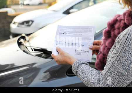 Donna controllando il suo DVLA auto imposta veicolo rinnovo avviso di promemoria Foto Stock