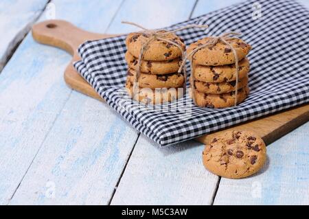 Due pile di biscotti con scaglie di cioccolato sulla verifica igienico coperto di legno Foto Stock