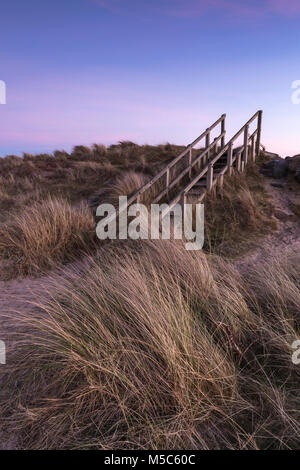 I gradini che conducono verso il basso attraverso le dune della spiaggia a Findhorn vicino a Forres, Scozia. Al tramonto. Foto Stock