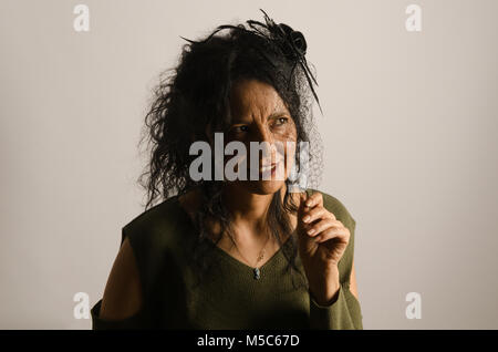 La luce artificiale ritratto in studio, donna con lunghi e capelli ricci, emozioni,sfondo bianco Foto Stock