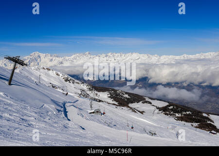 Pila, Aosta, Italia - 19 Feb 2018: seggiovia italiana al comprensorio sciistico di Pila su strade coperte di neve Alpi e alberi di pino durante l inverno con Mt. Blanc in Franc Foto Stock