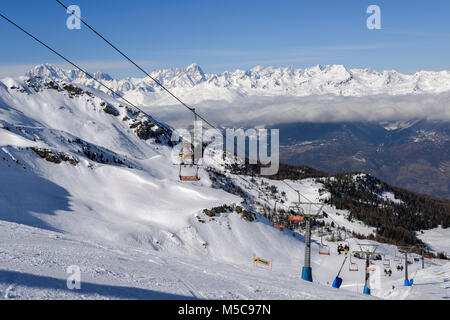 Pila, Aosta, Italia - 19 Feb 2018: seggiovia italiana al comprensorio sciistico di Pila su strade coperte di neve Alpi e alberi di pino durante l inverno con Mt. Blanc, Francia Foto Stock