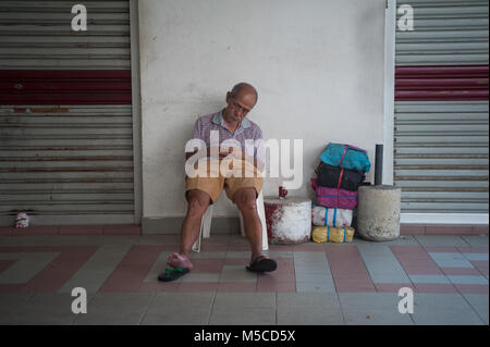 19.02.2018, Singapore, Repubblica di Singapore, in Asia - un uomo anziano si siede su una sedia al complesso di Chinatown shopping centre in Singapore Chinatown Foto Stock